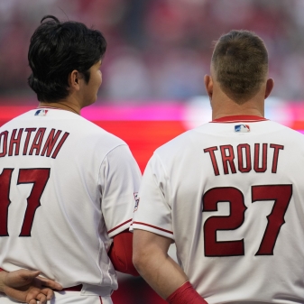 Los Angeles Angels designated hitter Shohei Ohtani (17) and center fielder Mike Trout (27) stand as the national anthem plays before a baseball game against the Toronto Blue Jays in Anaheim, Calif., Friday, April 7, 2023. (AP Photo/Ashley Landis)